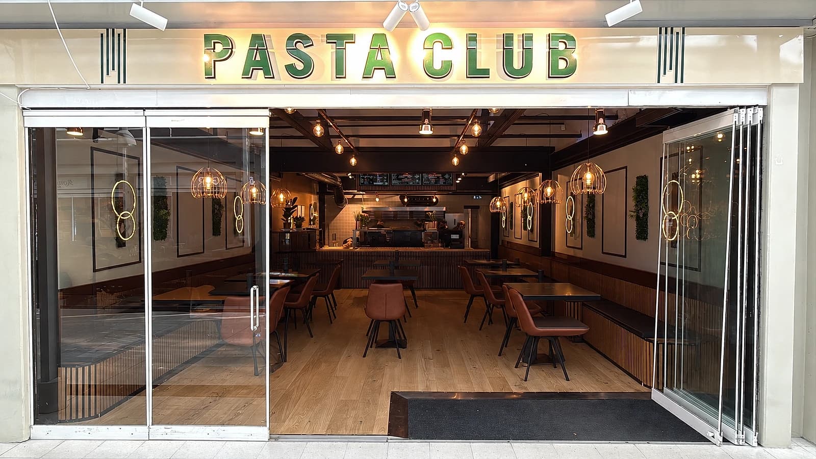 Pastaclubs indgang med det oplyste PASTA CLUB-skilt